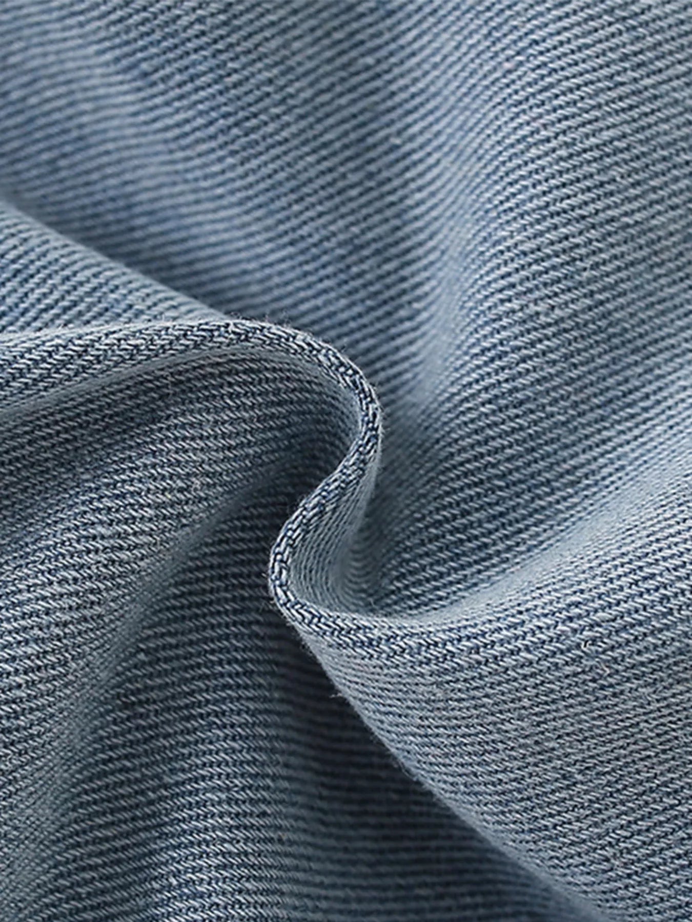 Close-up of textured blue fabric with a focus on stitching detail.
