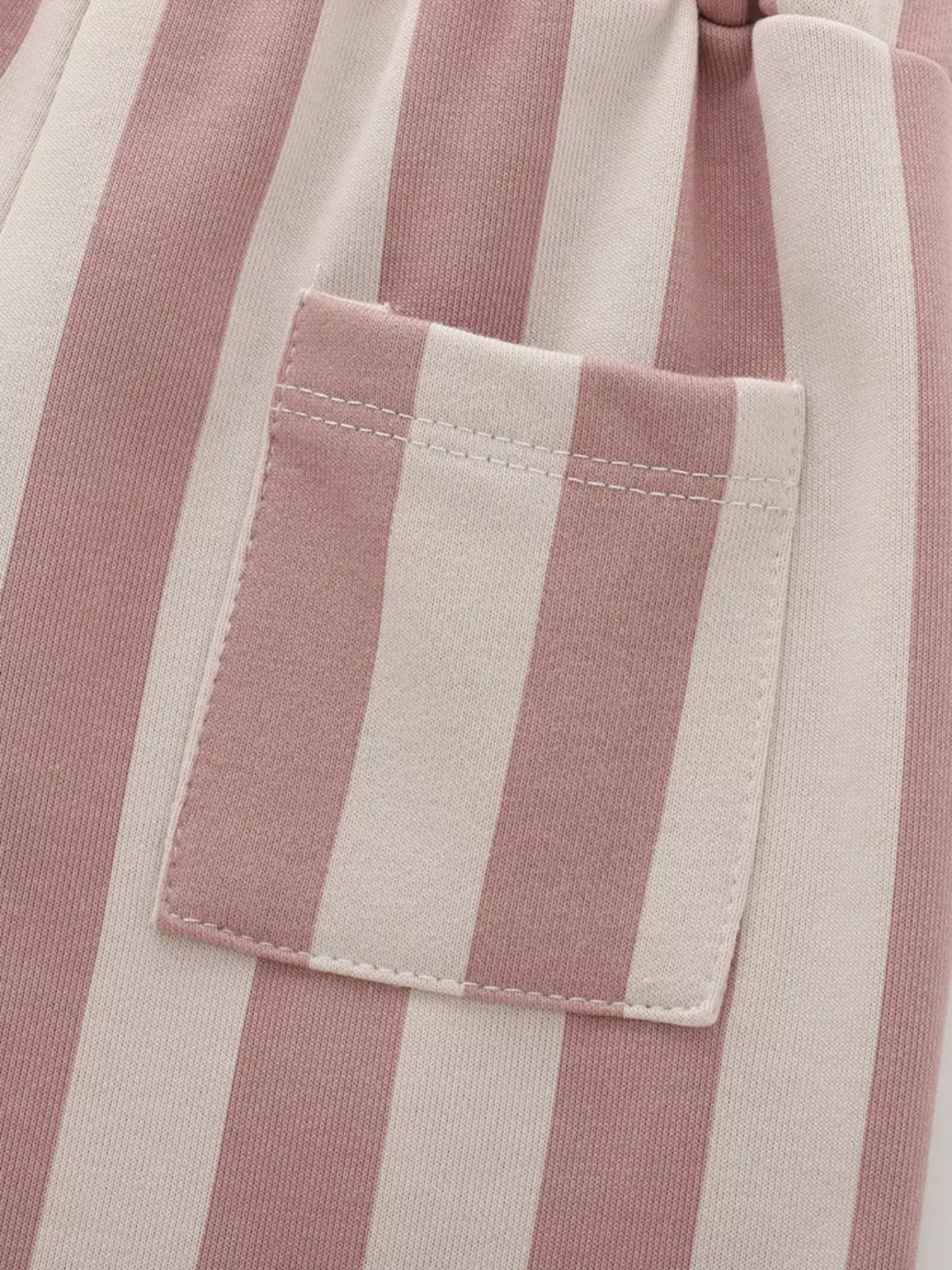 Close-up of a pink and white striped fabric with a pocket detail.