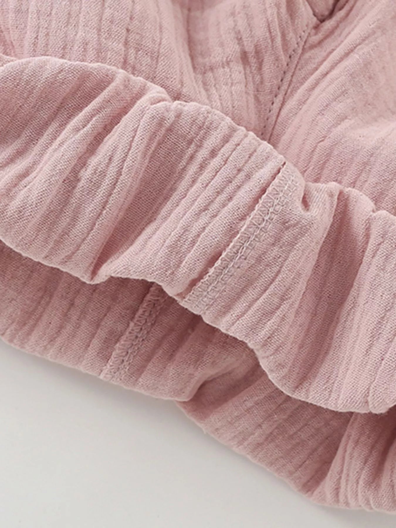 Close-up of a pink textured fabric on a light gray background