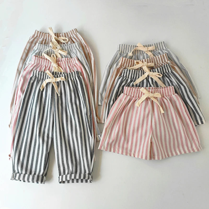 Striped pants and shorts with bow details on a light gray background